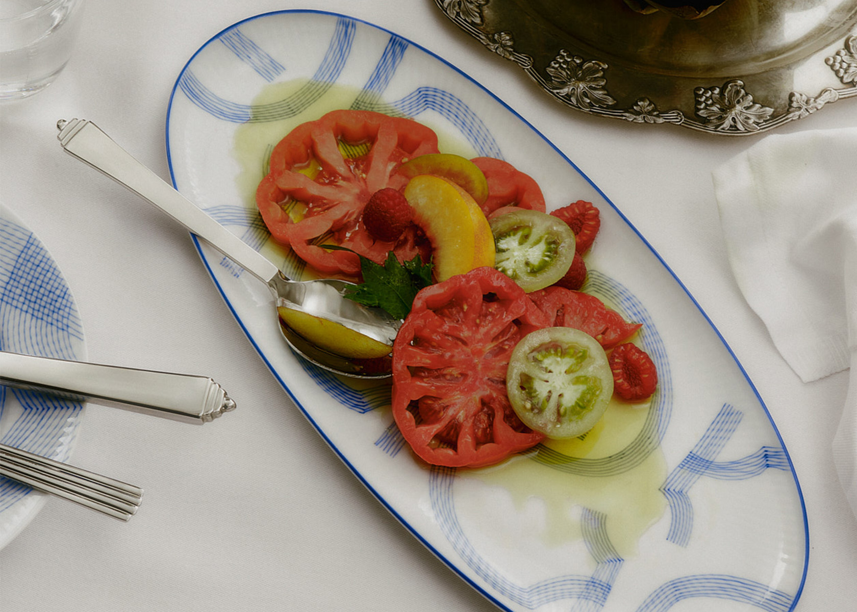 An oval dish from the collection motif with a tomato saled on it